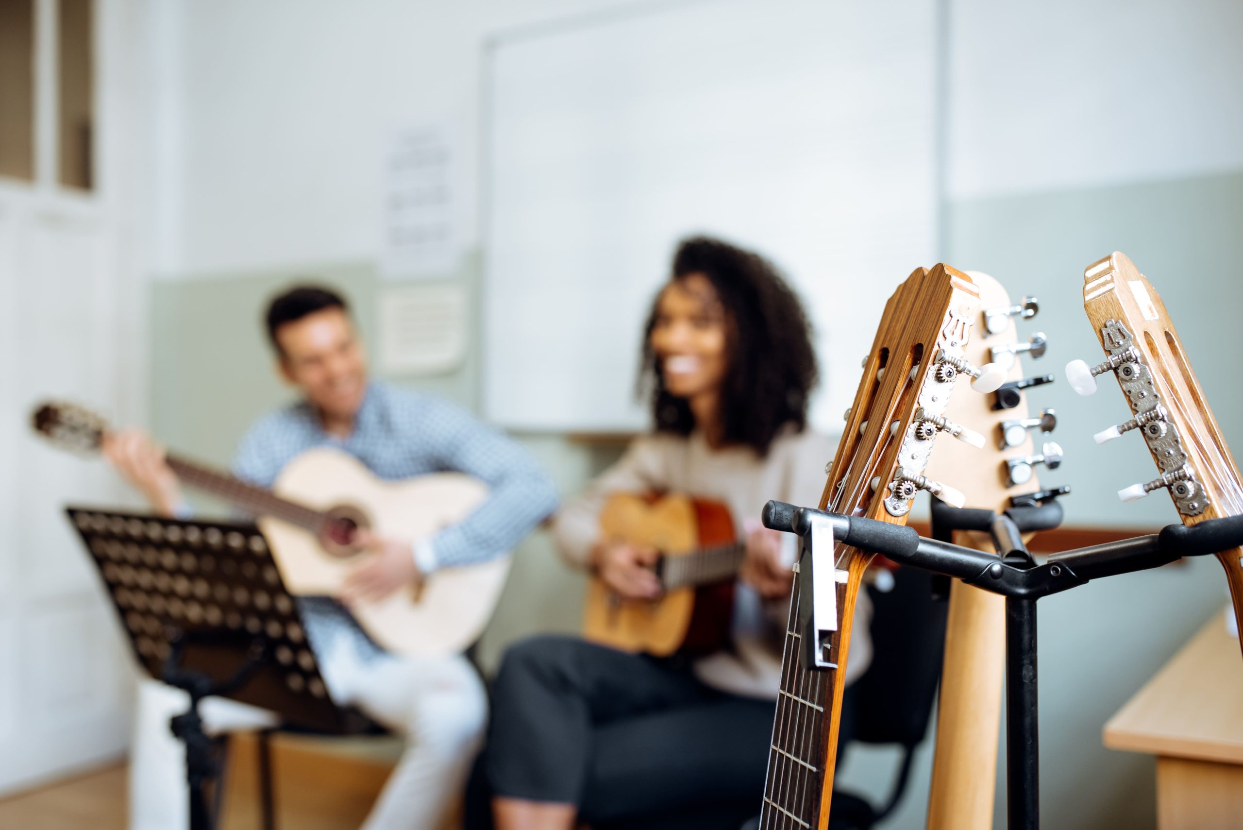 Profesor y alumna tocando guitarra en clase de música en Al Compás de la Vaguada